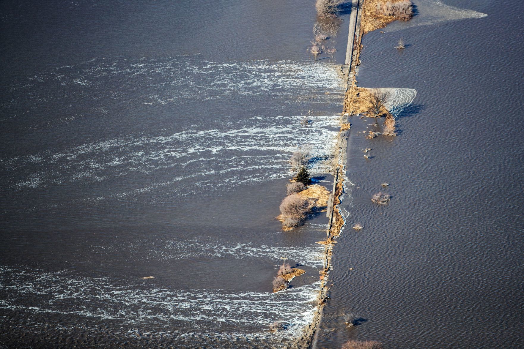 Floodwaters flow over a railroad bridge near Arlington, Nebraska, on Friday.